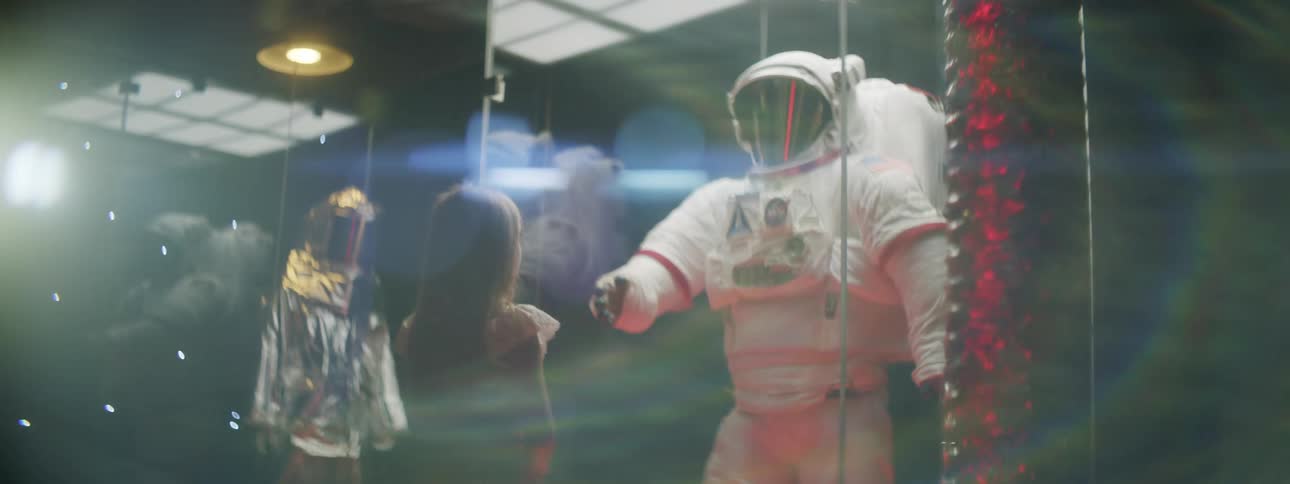 A girl looks at a display of an astronaut suit