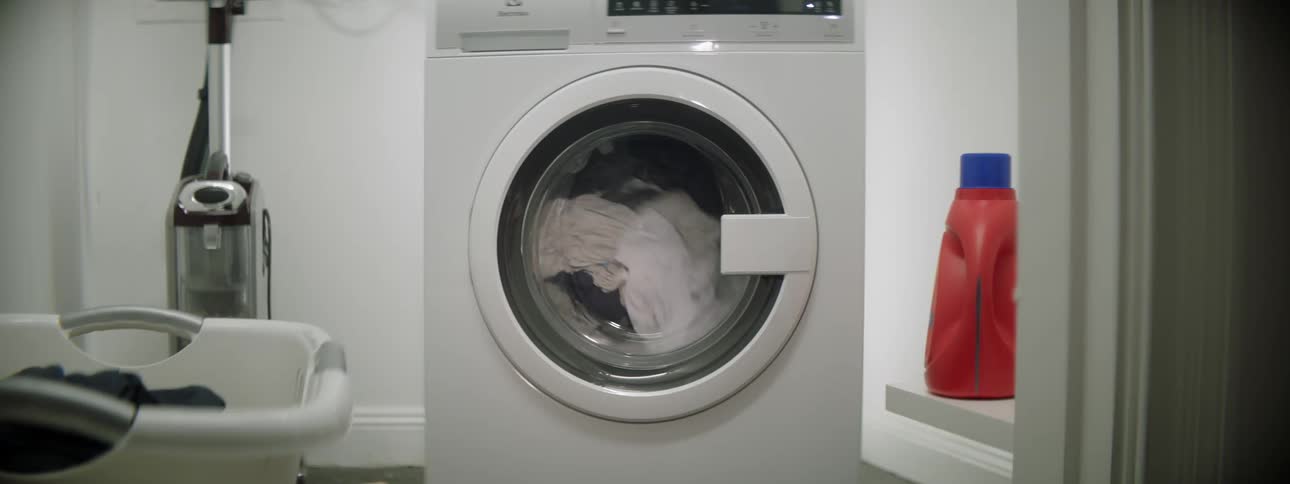 A white dryer is drying clothes then it stops