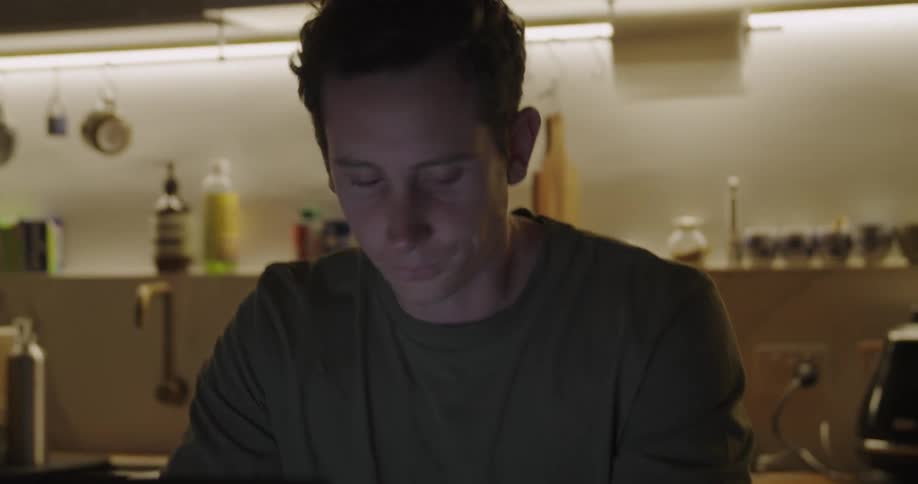 Man yawning trying to stay awake while studying in a restaurant kitchen