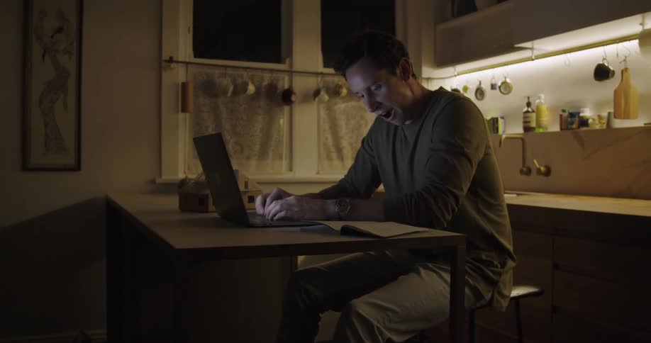 Man yawning trying to stay awake while studying at night