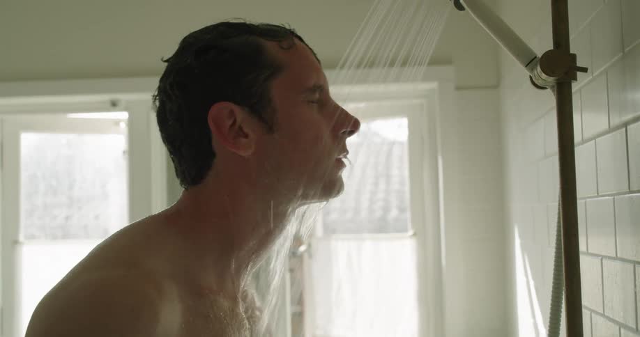 Man washing his hair and face in the shower