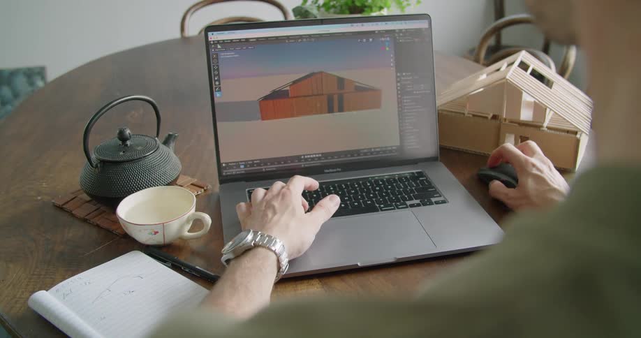 A man is using his laptop at the kitchen table