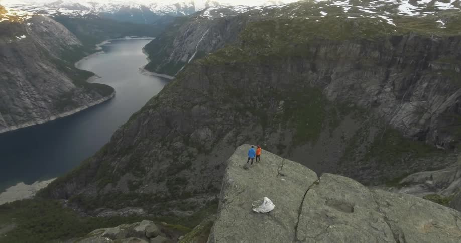 Aerial view of two people standing near the edge of a cliff