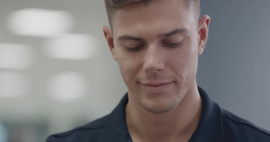 A man smiles as he looks down