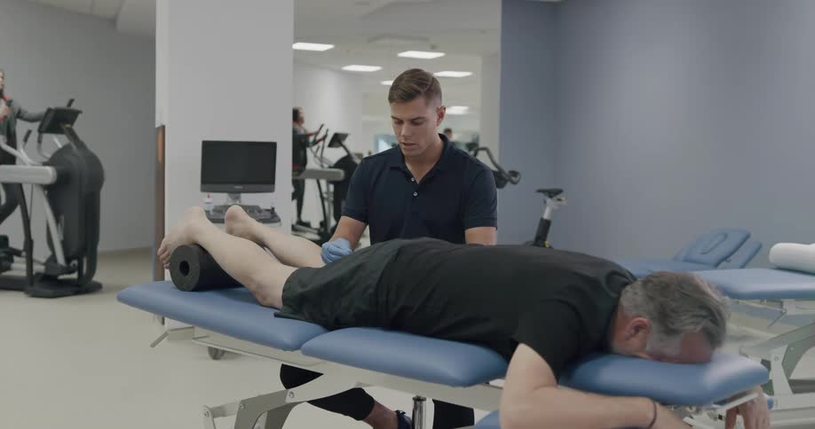 Senior citizen receives treatment on a stretcher in a fitness therapy center