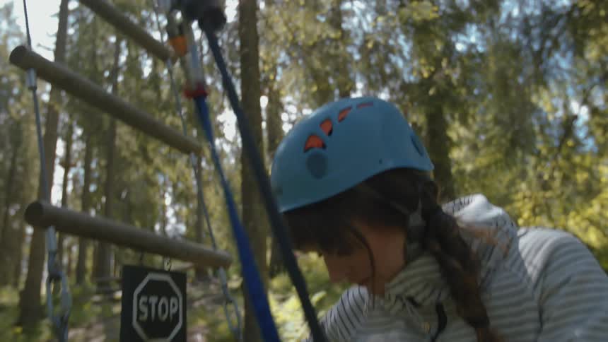 A woman in a blue helmet secures straps
