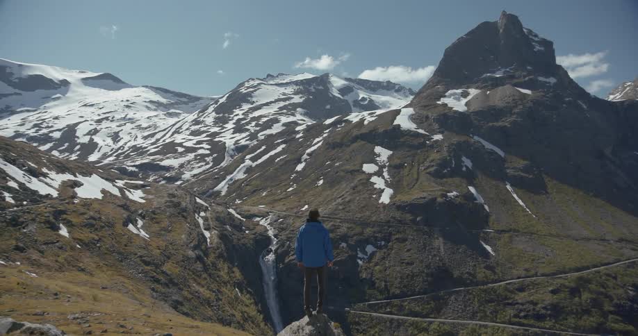 A woman stands on a cliff