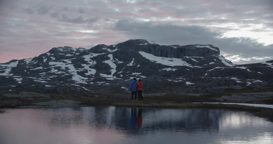 Two people look at a snowy mountain