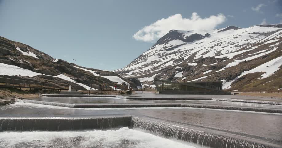 People are walking along a fountain on top of a mountain