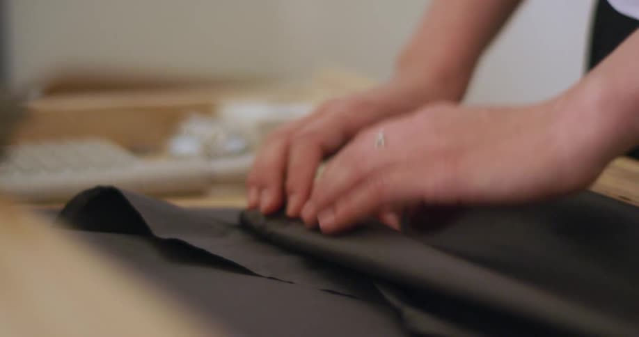 A retail employee wraps a purchase in black tissue paper