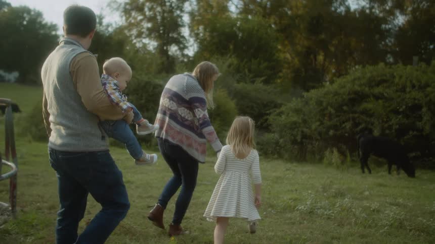 A family walking towards a cow