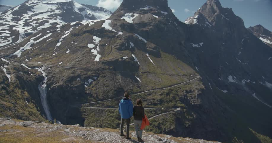 Two people are taking in a view from the edge of a cliff