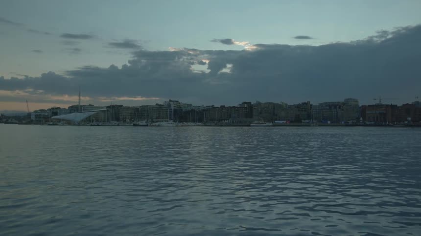 The sun is setting in the distance over a lake