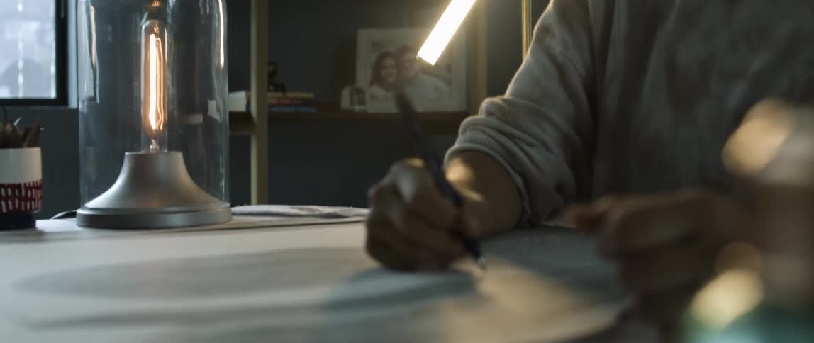 A woman creates a pointillism drawing with a black marker at home