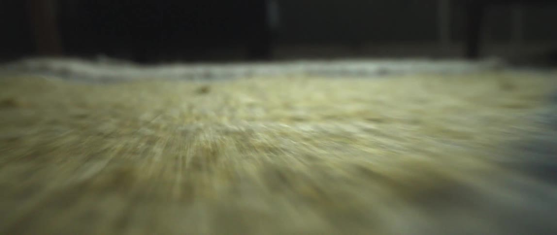 Close up of the floor with yellow blue and cream colored rugs
