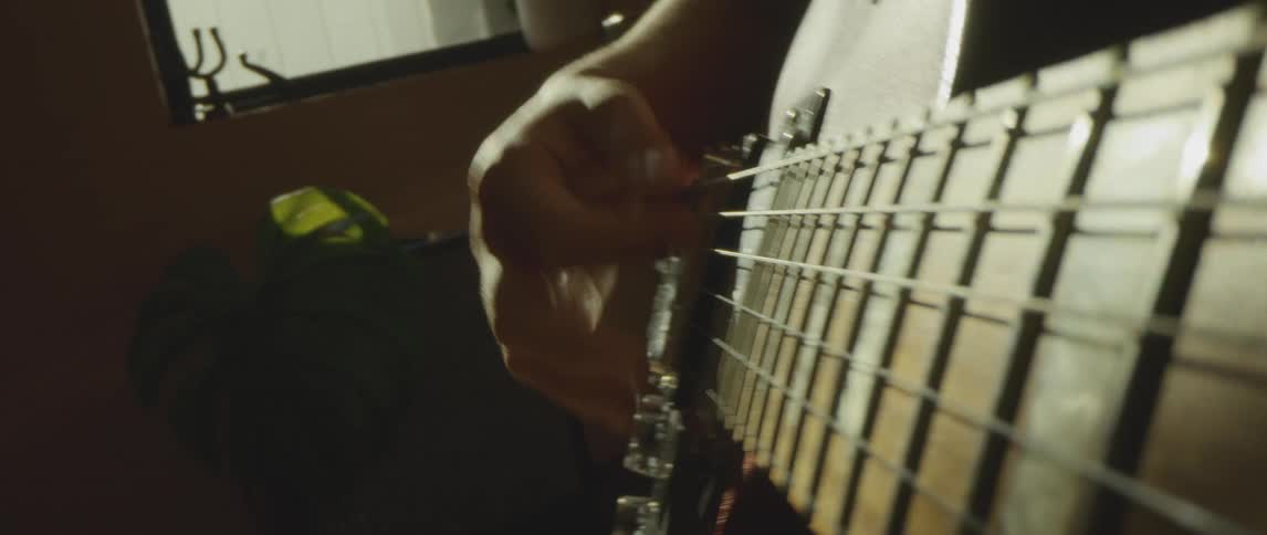 A person is playing guitar in their room