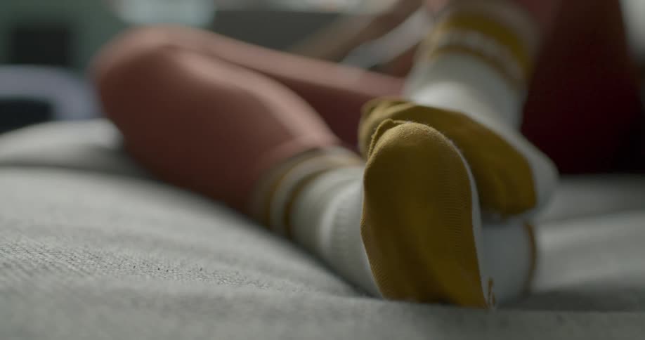 Young woman laying on the couch on the living room wearing socks