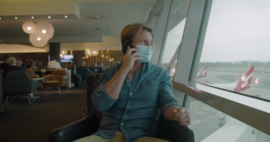 A man in an airport lounge talking on a phone
