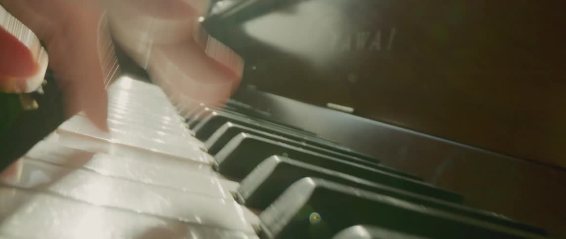 A person in a room playing the piano while holding a guitar with a window in the background