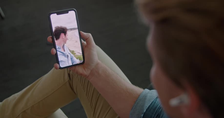 Two male friends video chat with one another on a cell phone