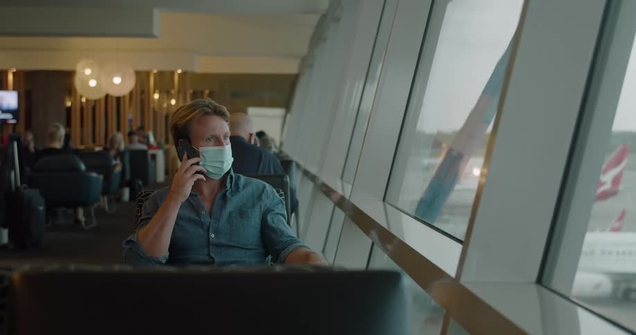 A man is talking on his cell phone in the airport terminal