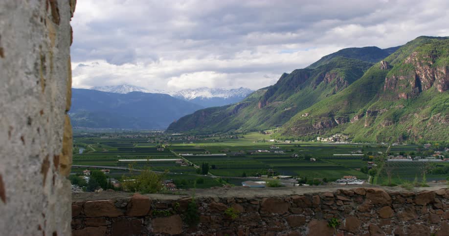 Vehicles drive past rural neighborhoods location at the base of a canyon