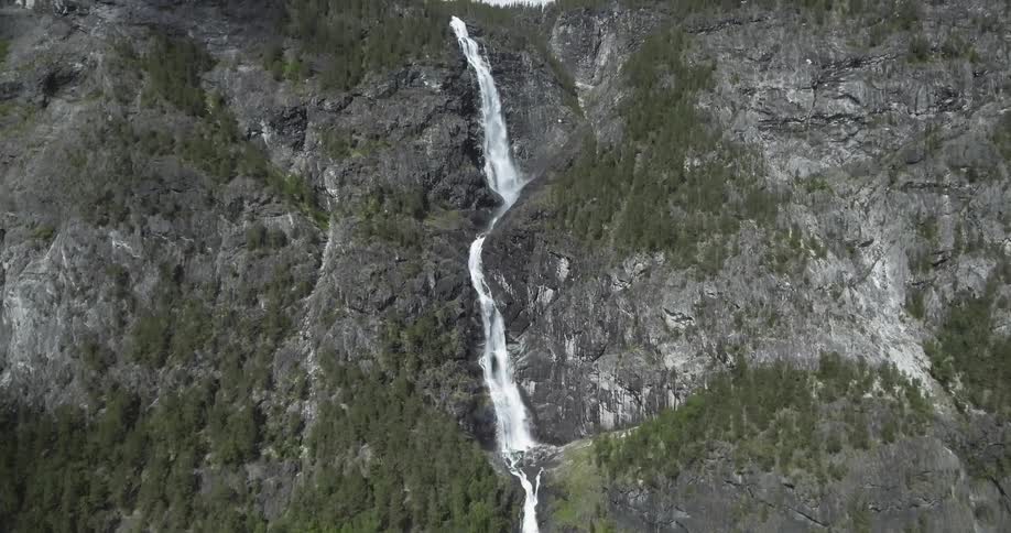 Tall waterfall flowing down a large mountain side