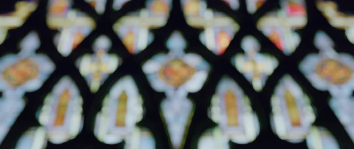 A beautiful and colorful stained glass window is filled with interesting designs