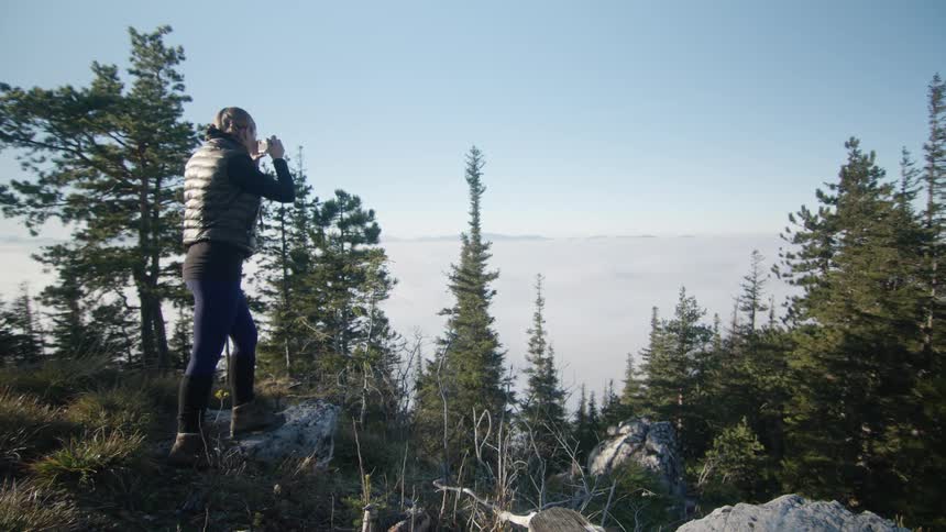 A woman is hiking through a forest