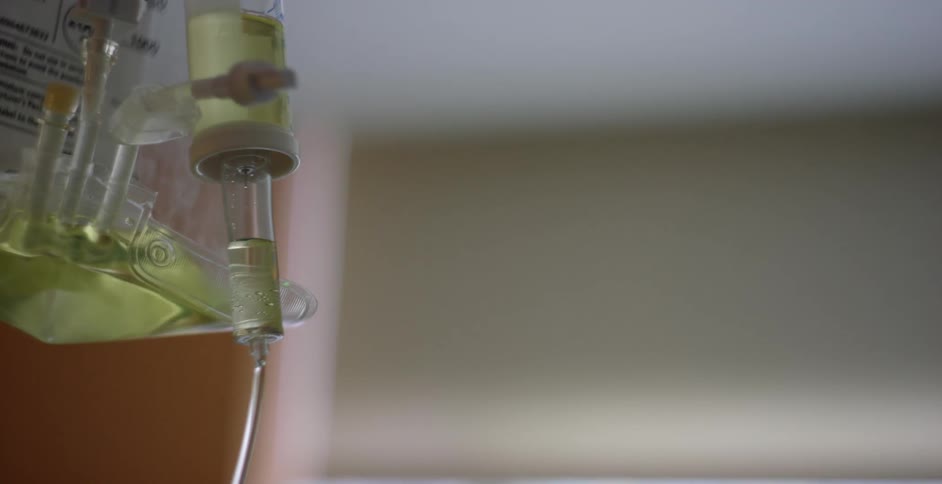 Close up of the valve of a dripping intravenous therapy bag