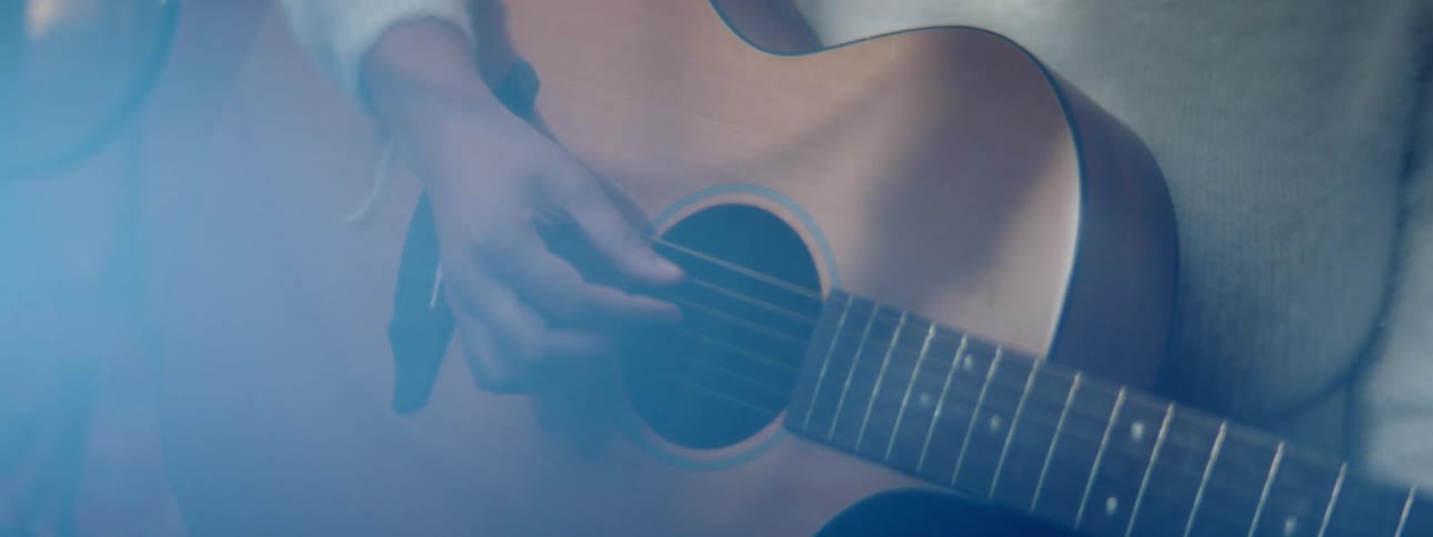 A close up of a person playing guitar