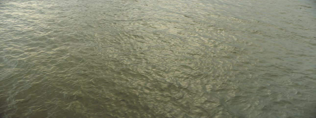 Muddled calm waters of a river or lake at sunset or morning