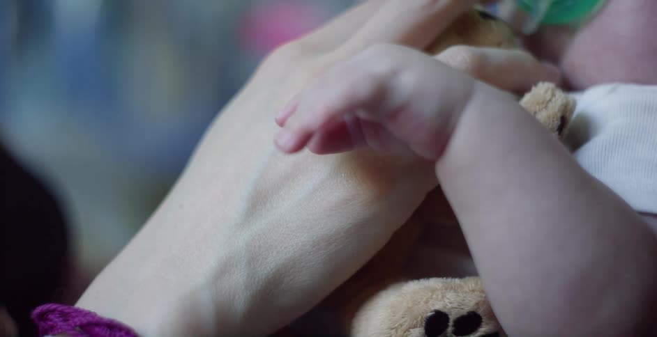 Mother holding a small oxygen mask on a babys face
