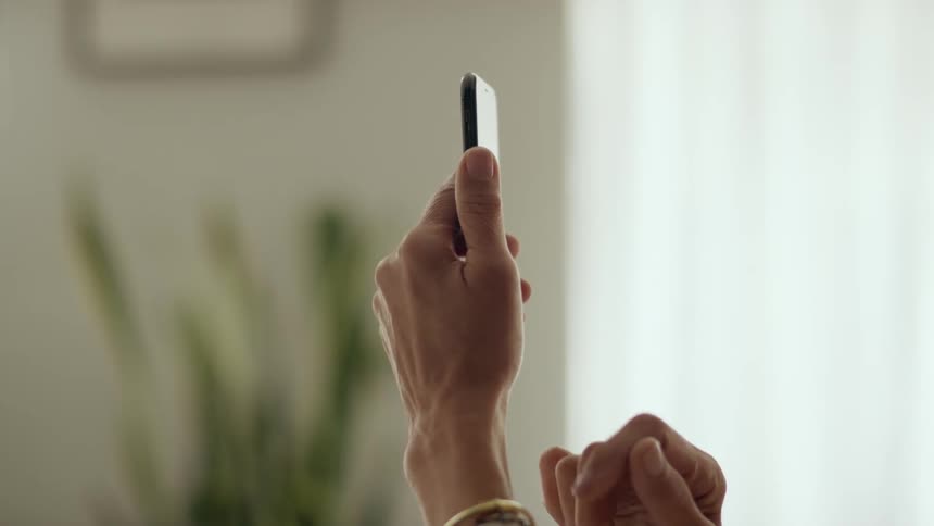 A person holds a smartphone up and taps the screen