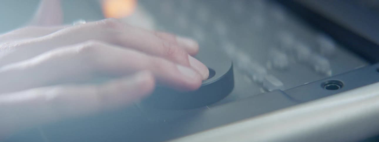 A person turning a dial on an electric mixer with buttons and lights