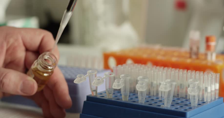 A lab technician is filling vials with an instrument