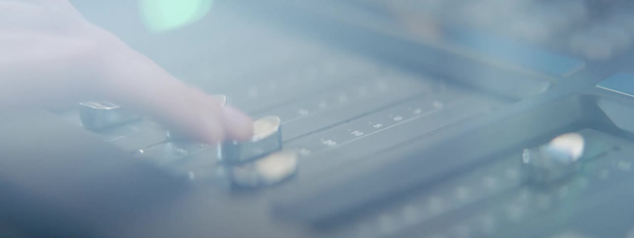 A person pushing buttons on a mixed board