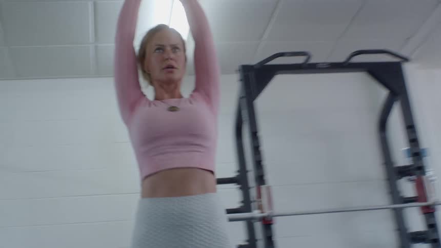 A woman exercises with a kettle bell