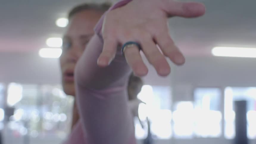 A woman raises her hands above her head as she exercises