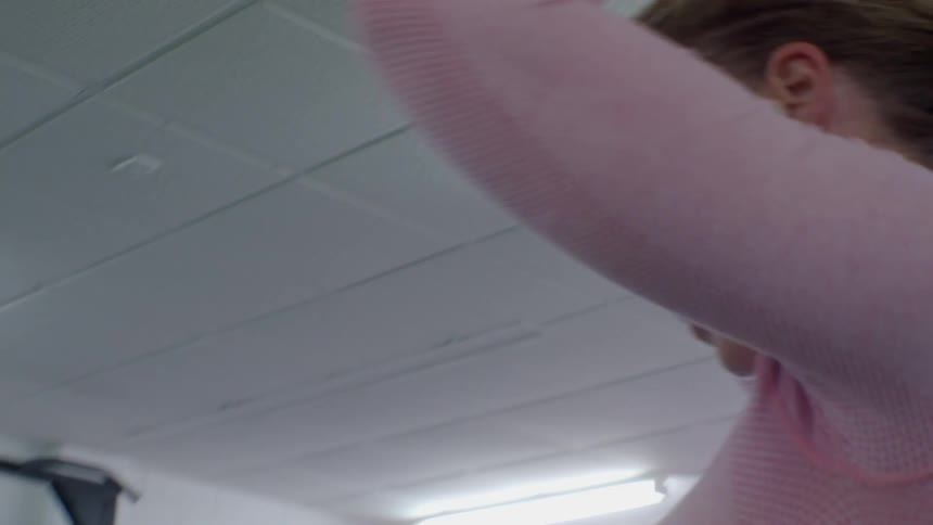 A woman putting her hair in a ponytail