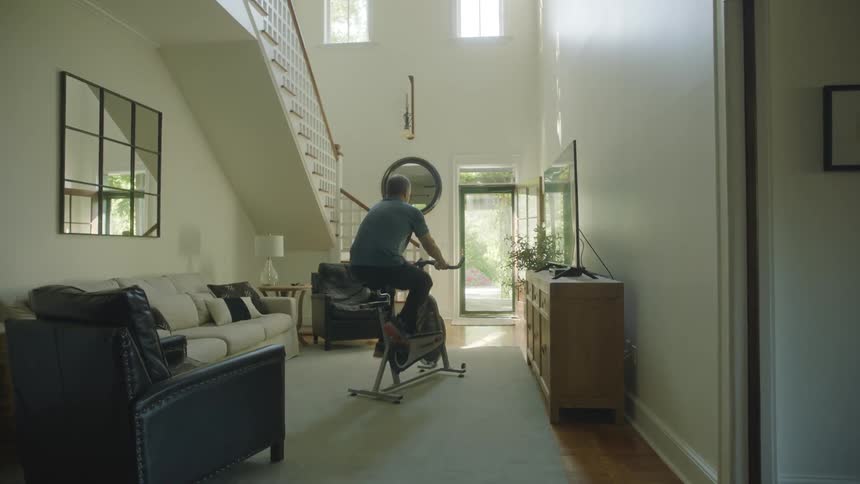 A man is exercising on a bike indoors
