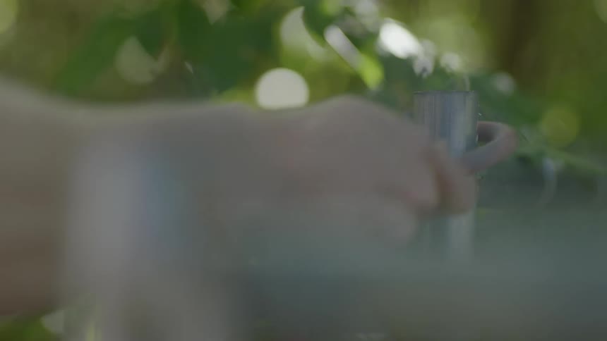 A person puts a red tube around a metal pipe in the garden
