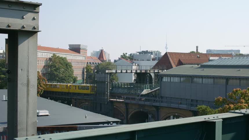 A train driving through a train station in a city
