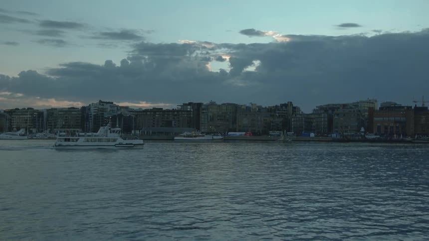 A boat passes in front of a city