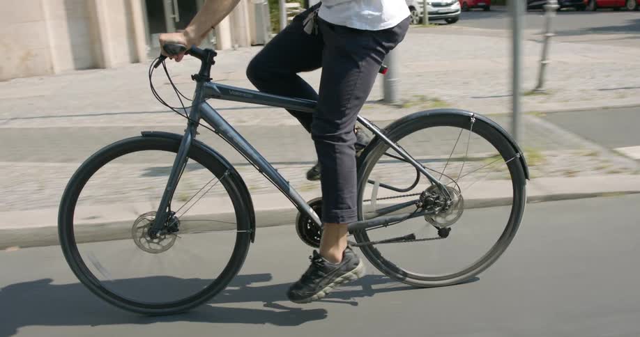 Cyclist riding a bicycle on a road in the city at daytime