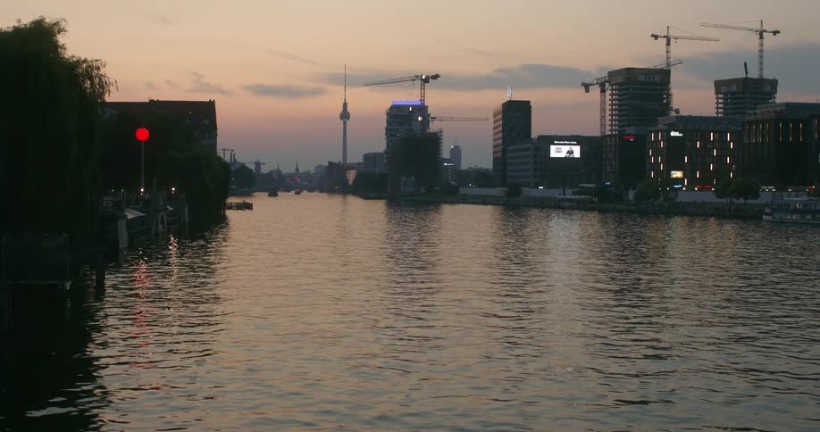 The sun is setting in the horizon of a downtown city