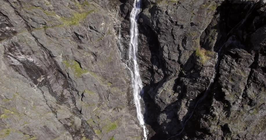 A waterfall pours water down a steep mountain