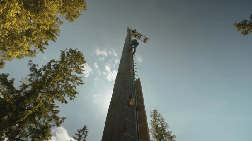 A person climbs a tall pole
