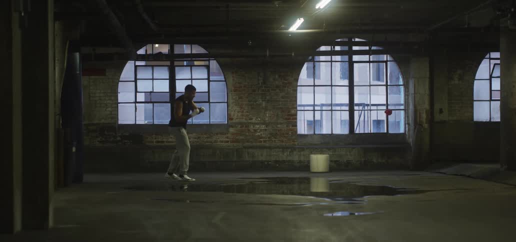 A man is shadowboxing in the empty building