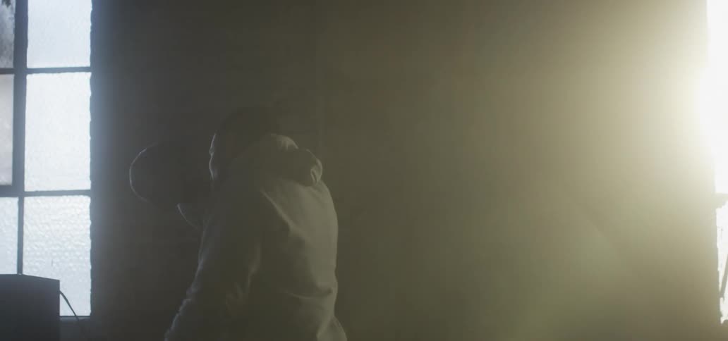 Young boxer training inside an abandoned warehouse at sunset